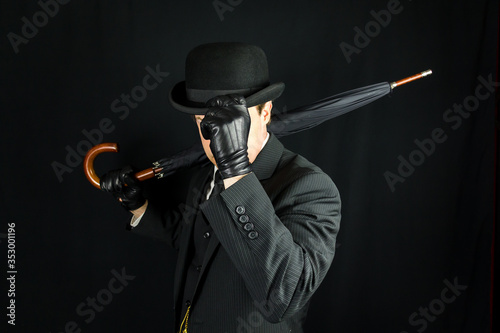 Billede på lærred Portrait of British Businessman in Dark Suit and Bowler Hat Holding Umbrella