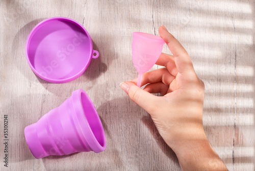 Woman hand holding a menstrual cup - Female hygiene, gynecology and health concept photo