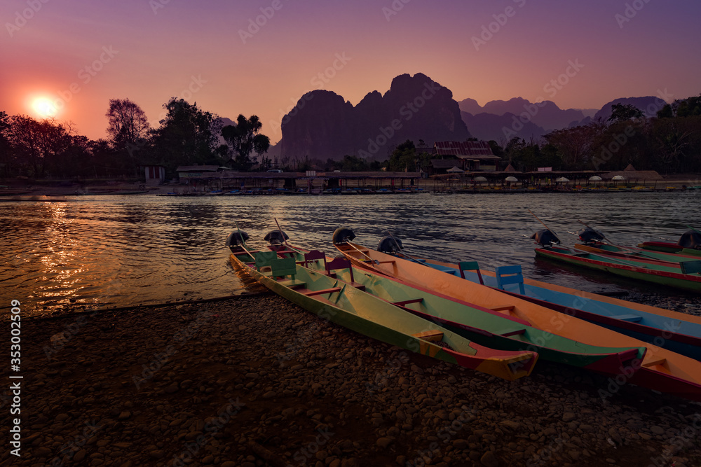 Fototapeta premium Colorful Wooden Boats Nam Song River at Sunset Vang Vieng Laos