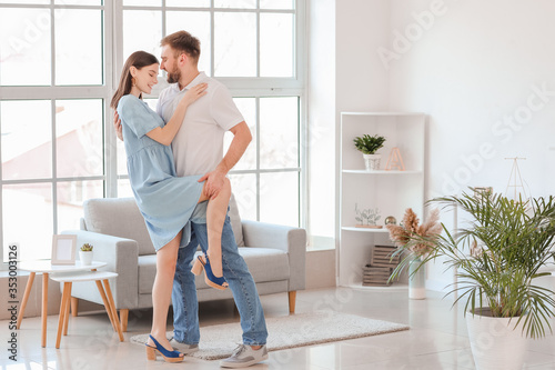 Happy young couple dancing at home