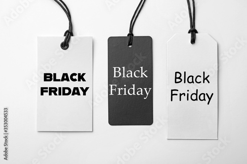 Different tags with text BLACK FRIDAY on white background, flat lay