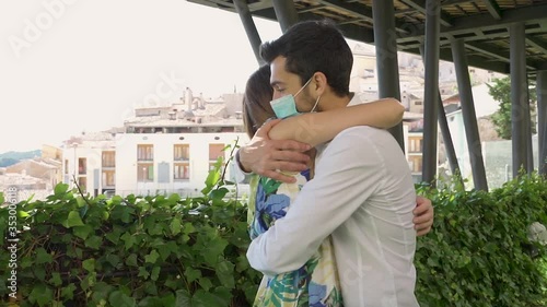 Young couple meet and hug with a medical mask, pandemic, covid-19.