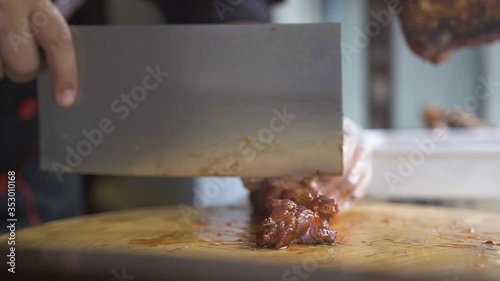 Chinese style barbecue pork being sliced on cutting board photo