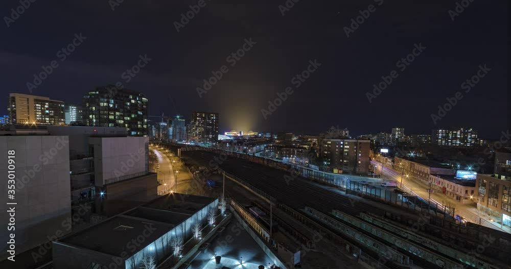 Wide angle night city time-lapse overlooking train tracks just outside downtown Toronto Ontario, Canada , from a high rise building. Lights from BMO Field can be seen in the distance. Wide angle night city time-lapse overlooking train tracks just outside downtown Toronto Ontario, Canada , from a high rise building. Lights from BMO Field can be seen in the distance.
