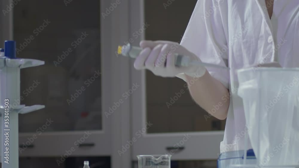 Young female scientist using pipette for blood in laboratory, middle shot view Young female scientist using pipette for blood in laboratory, middle shot view