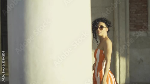 Fashion girl walking behind palace columns photo