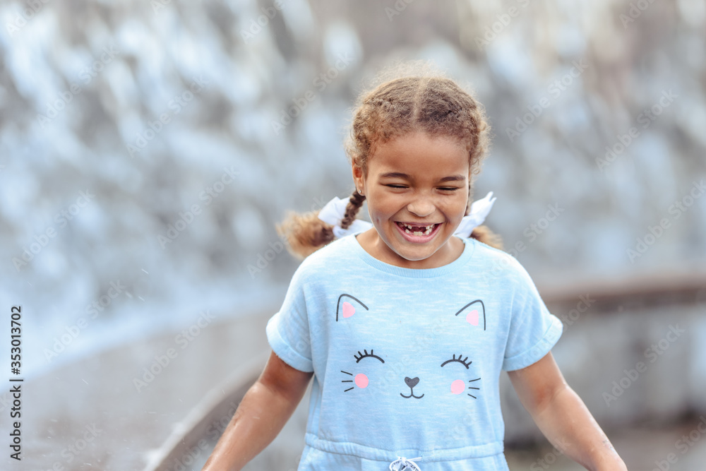 Happy beautiful girl running through the spray of water. Happy beautiful girl running through the spray of water.