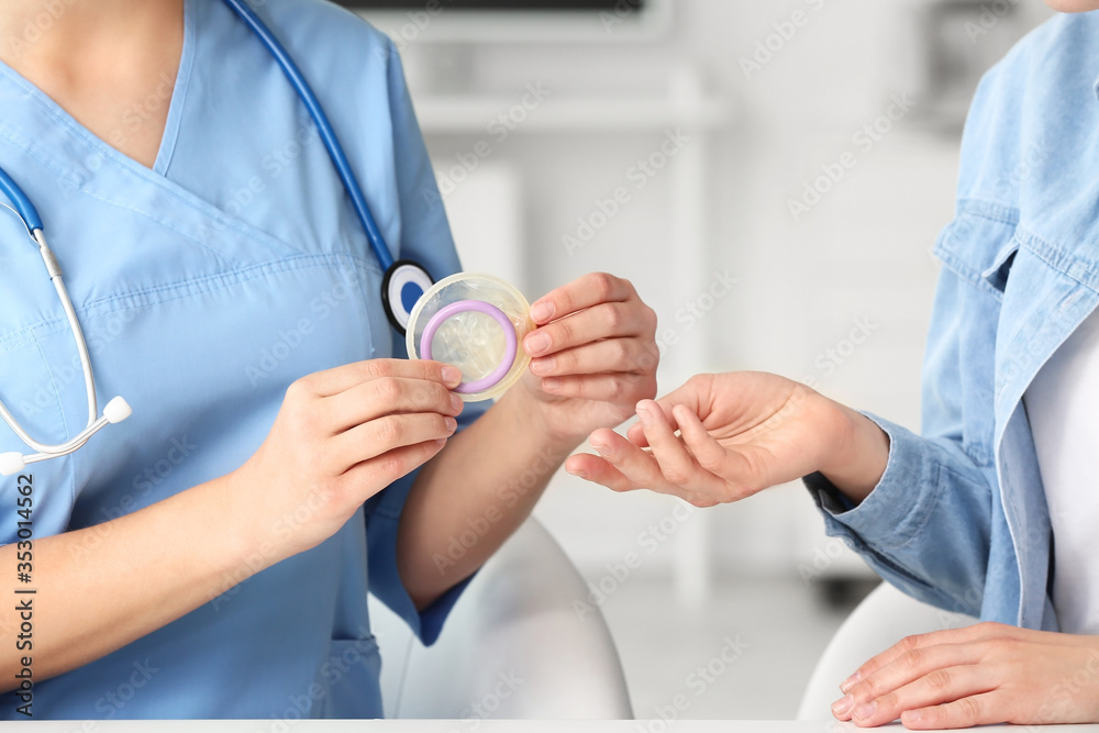 Female gynecologist and patient with condom in clinic