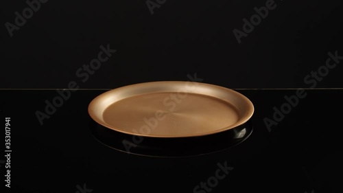 Male waiter opening empty tray on dark background