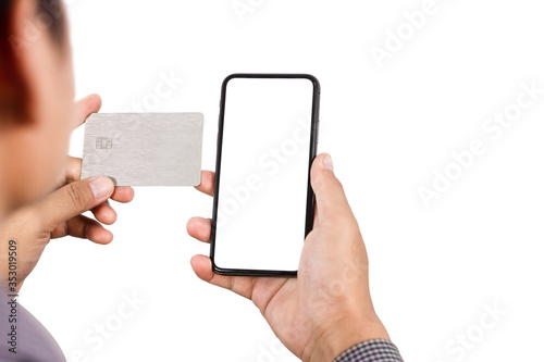 The hands of an Asian man holding a credit card and using phone payments to make online purchases with a credit card in a phone application or home stay website and buying products online.