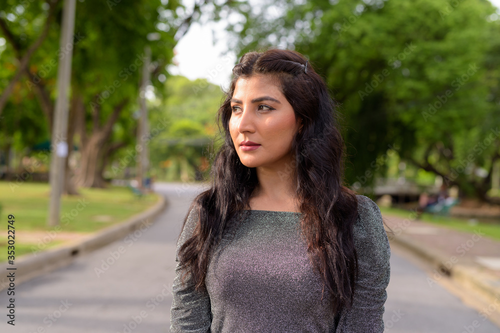 Young beautiful Indian woman thinking in the streets at the park Young beautiful Indian woman thinking in the streets at the park