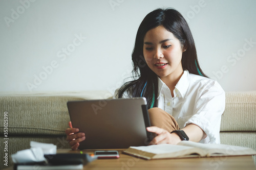 Woman relaxing on sofa in the living room enjoying sunny morning on the day Happy casual beautiful woman working on a laptop sitting in the house. 