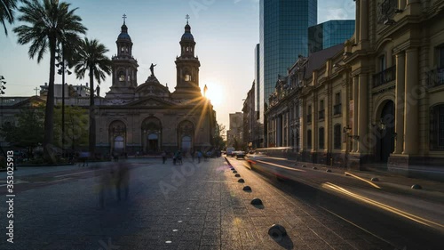 Time lapse view of sun setting behind historical landmark Santiago Metropolitan Cathedral at Plaza de Armas square in downtown Santiago, the capital and largest city in Chile, South America. 