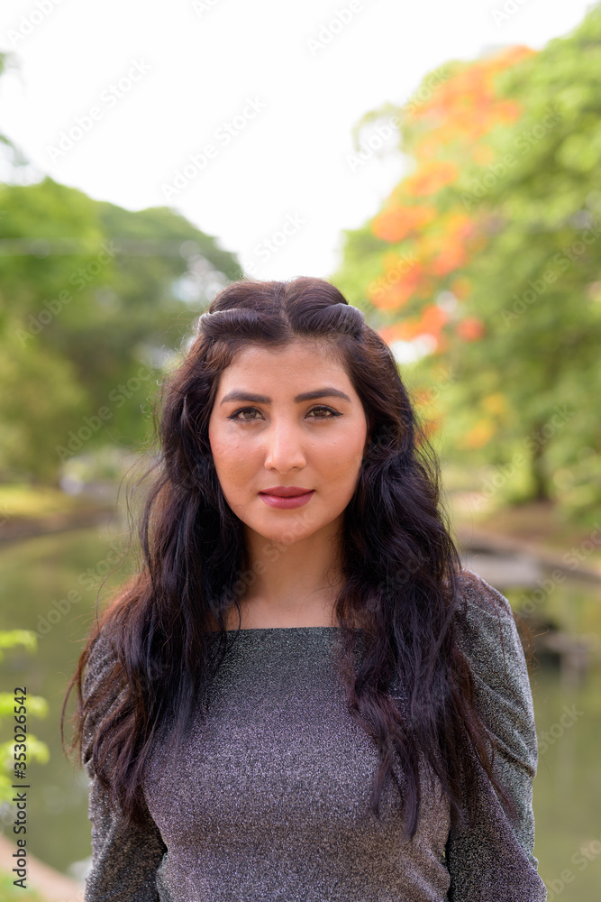 Face of young beautiful Indian woman at the park outdoors Face of young beautiful Indian woman at the park outdoors