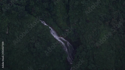 Cascada entre montañas y terrazas de arroz desde vista aérea