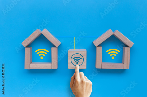Model house with wifi signs on blue background. Connect global wireless devices. Booking house online
