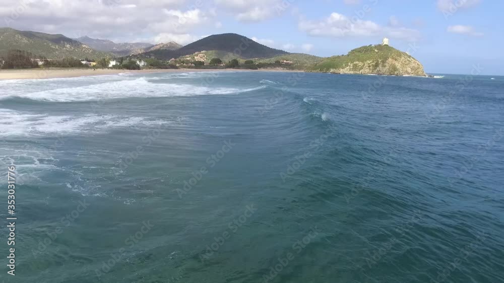 Drone flies in sync with a wave at a beach in the south of Sardinia Drone flies in sync with a wave at a beach in the south of Sardinia