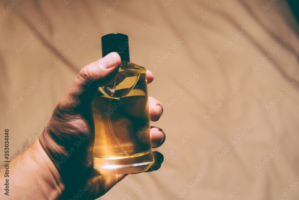 Man holding a bottle of perfume -  backlight - obrazy, fototapety, plakaty 
