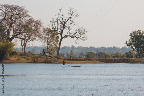  fisherman on canoe in tropical Bungva lake, Laos photo