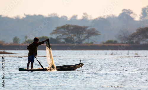  fisherman on canoe in tropical Bungva lake, Laos photo