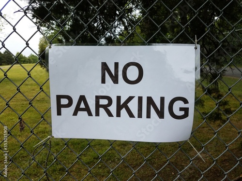 no parking sign on metal chain link fence