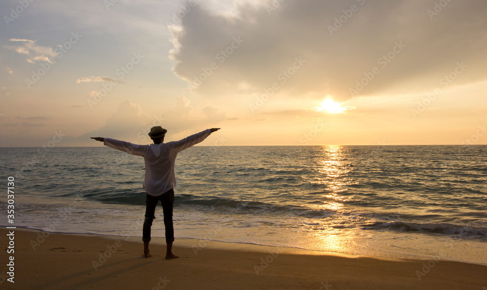 silhouette young man standing on the beach with happy relaxing on summer time at sunset, Summer vacation concept