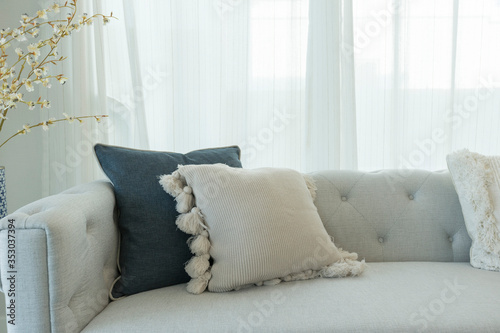 Blue and white pillows on a white sofa, living room interior.