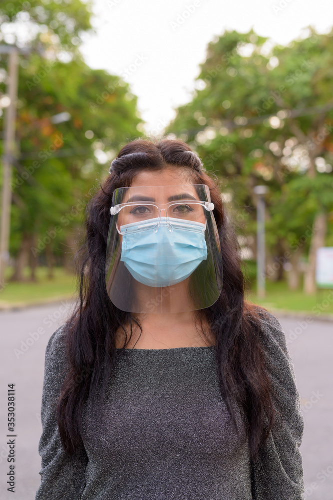 Young Indian woman wearing mask and face shield at the park outdoors Young Indian woman wearing mask and face shield at the park outdoors