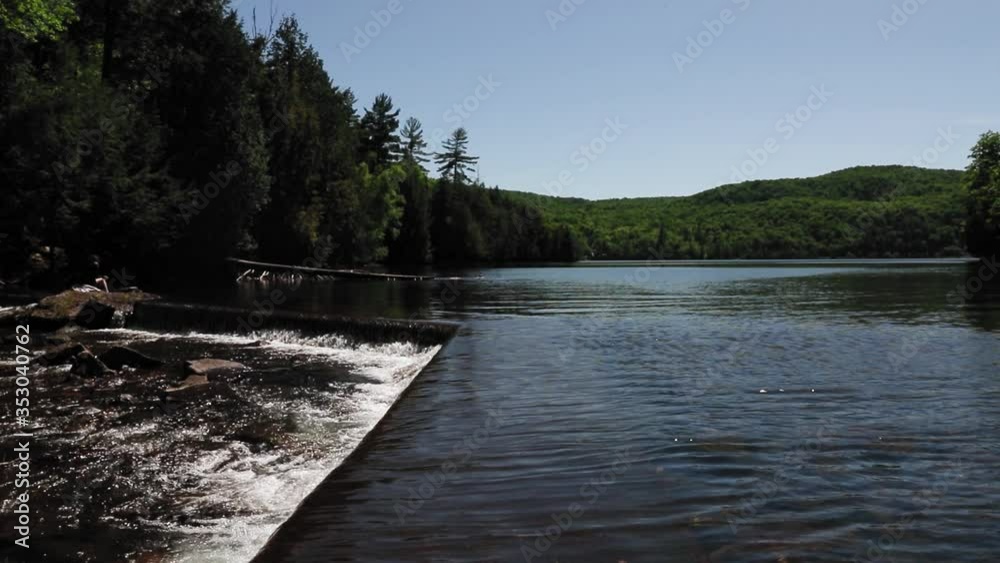 Walking along a small man made cement damn where the water exits Meech lake in the middle of the Gatineau provincial park in Quebec. Walking along a small man made cement damn where the water exits Meech lake in the middle of the Gatineau provincial park in Quebec.