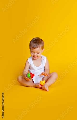 a little boy sits and tries to connect the details from an educational game such as a pyramid
