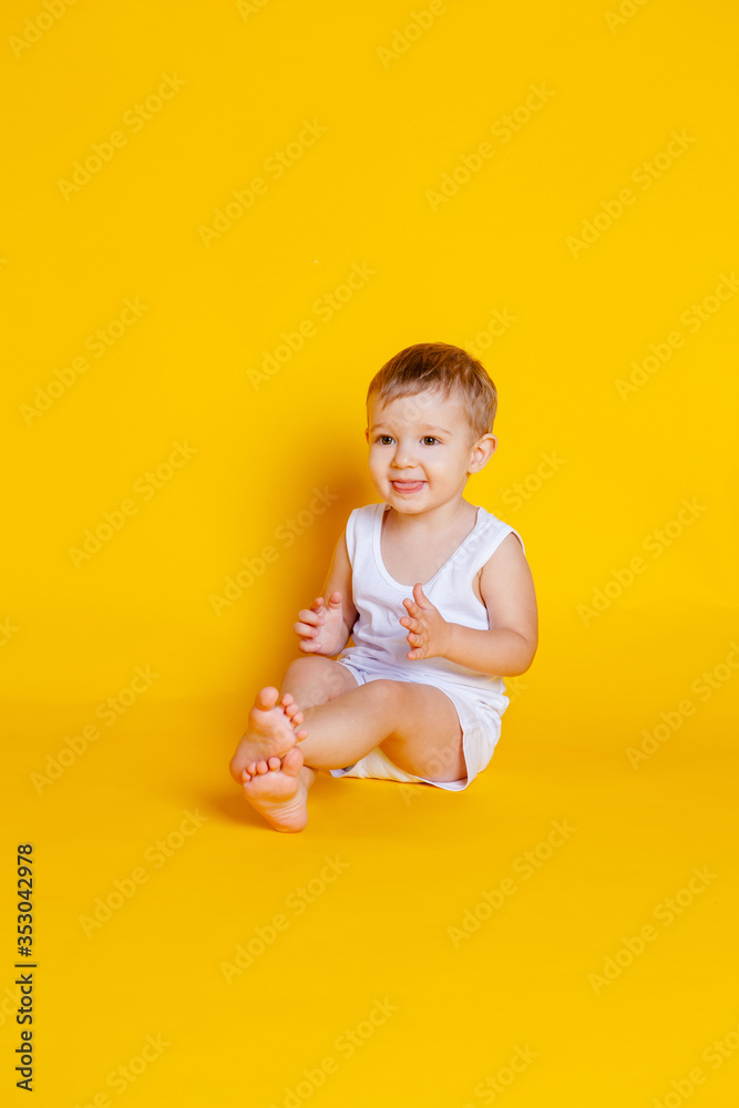 little boy in a t-shirt and underwear sitting on an orange-yellow background little boy in a t-shirt and underwear sitting on an orange-yellow background