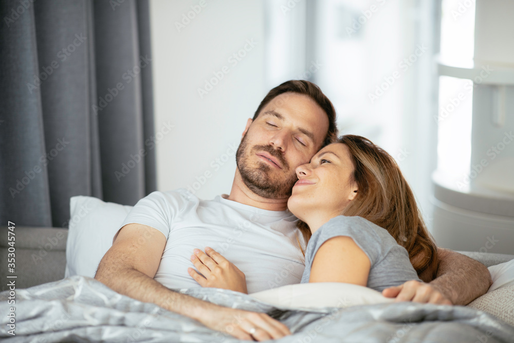 Young loving couple in bed. Happy couple relaxing in bed. Young loving couple in bed. Happy couple relaxing in bed.