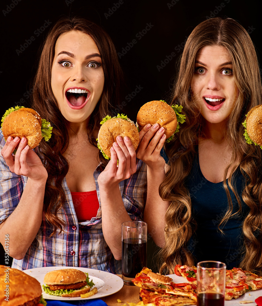 Group women eat best hamburger and pizza in burger bar . Friends take fast food drink cola and chatting. Group women eat best hamburger and pizza in burger bar . Friends take fast food drink cola and chatting.