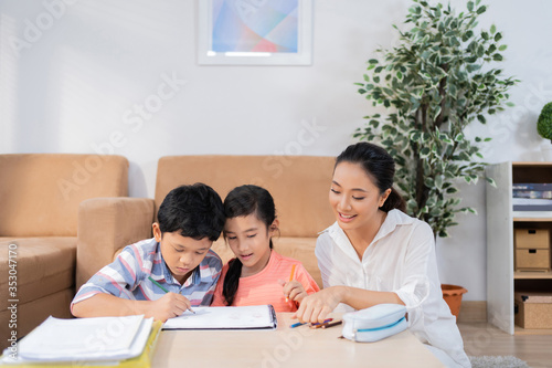 Son and daughter studying online His mother helped teach homework.