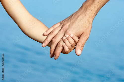 beautiful hands of parent and child by the sea