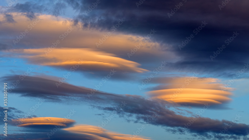 Lenticular clouds light up yellow as the sun sets, Yorkshire,UK