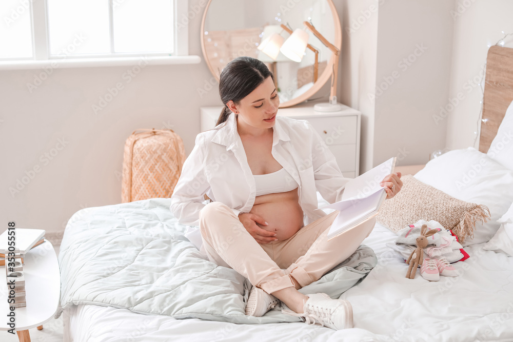 Beautiful pregnant woman reading book at home Beautiful pregnant woman reading book at home
