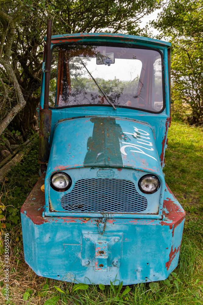 An old abandoned blue two-places car in the village
