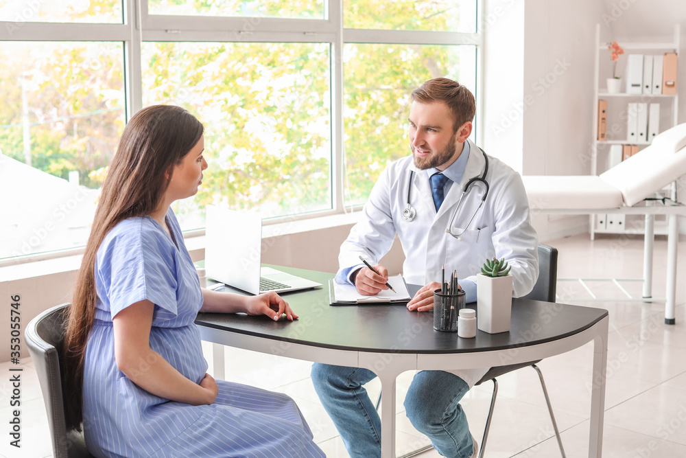 Obraz premium Young pregnant woman visiting doctor in clinic