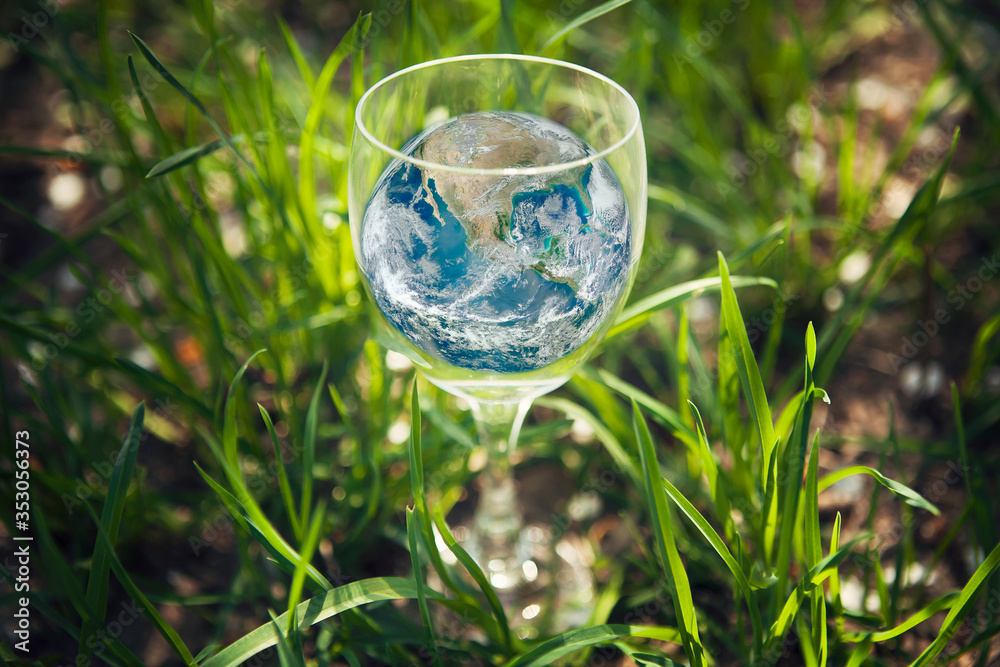 Planet Earth in glass on green grass background. World environment day concept. Elements of this image furnished by NASA Planet Earth in glass on green grass background. World environment day concept. Elements of this image furnished by NASA