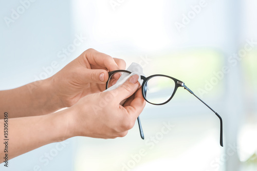 Fototapeta Naklejka Na Ścianę i Meble -  Woman disinfecting eyeglasses at home