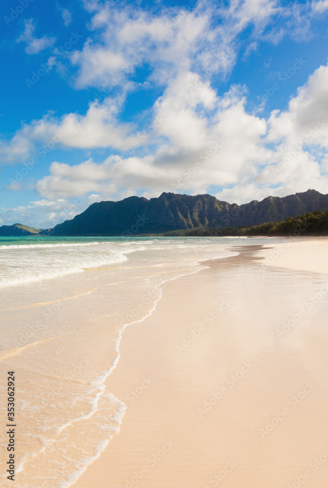 Beautiful Hawaii beach coastline and mountains landscape on a sunny blue cloud summer day.