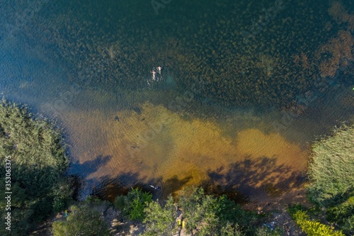 Holiday vacation on the sandy beach, sunbathing i swimming in the water aerial drone photo