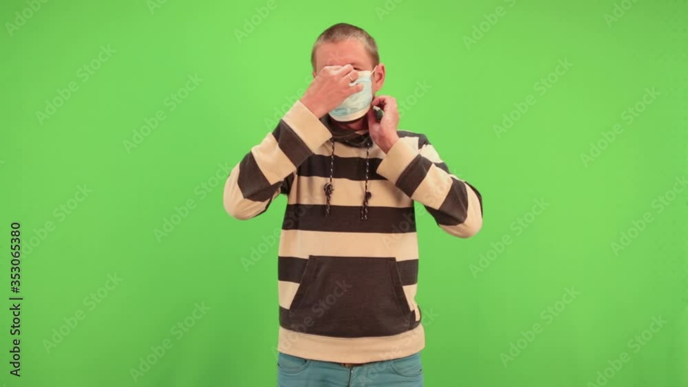 Man puts on medical mask on chromakey. Virus protection gel, disinfectant. Prevent spread of coronavirus covid-19. Man puts on medical mask on chromakey. Virus protection gel, disinfectant. Prevent spread of coronavirus covid-19.