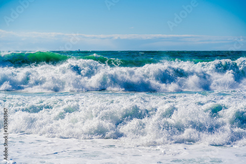 Beautiful storm waves in white foam in the Black sea. A sea of interesting emerald hue.