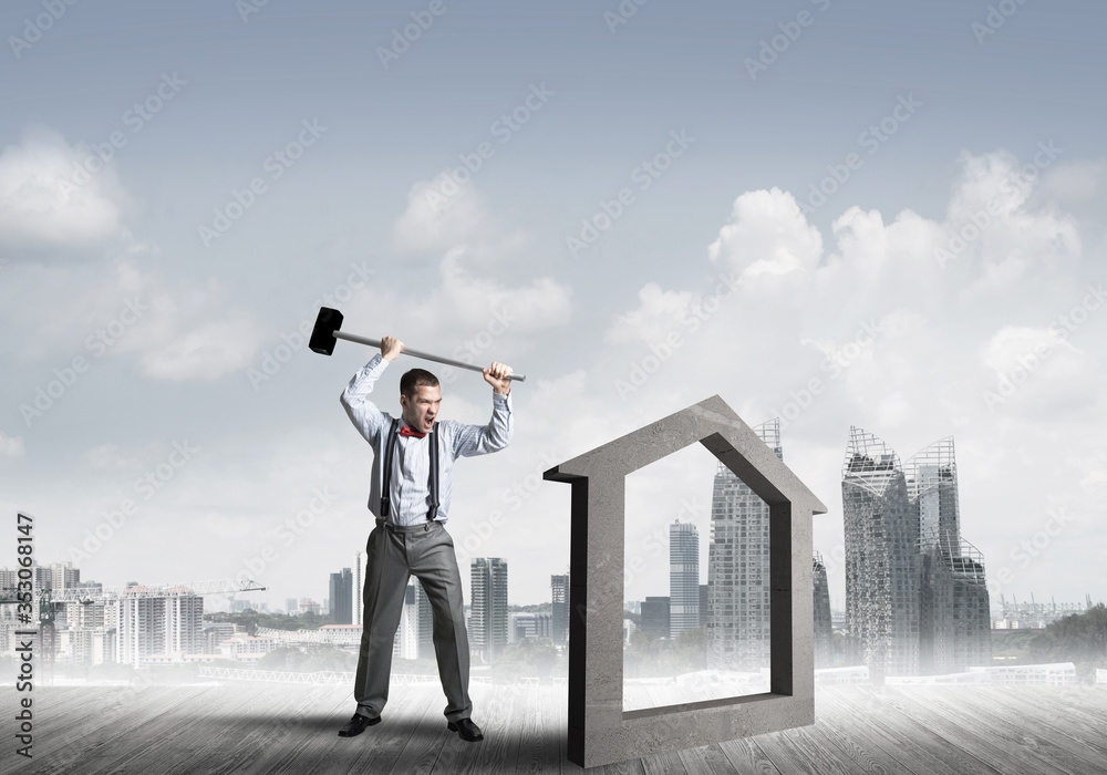 Manager man crashing stone home as symbol for real estate insurance Manager man crashing stone home as symbol for real estate insurance