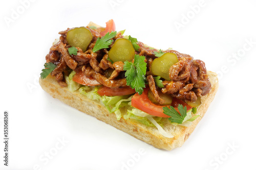 grilled toast with meat in sauce, parsley, green salad and pickled cucumber isolated on white background