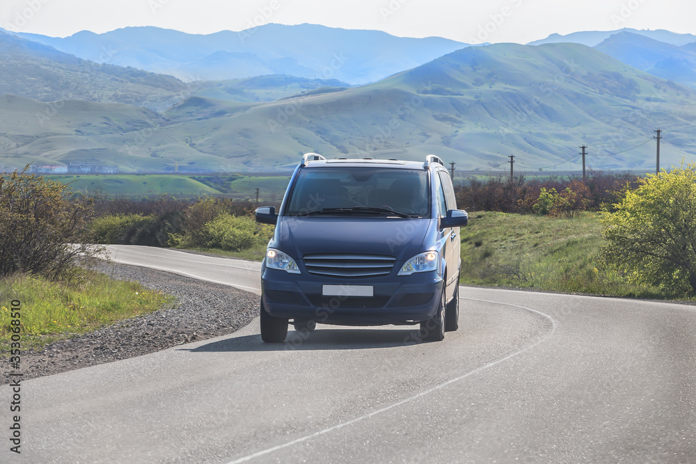 Minivan moves along a winding road in the mountains Minivan moves along a winding road in the mountains