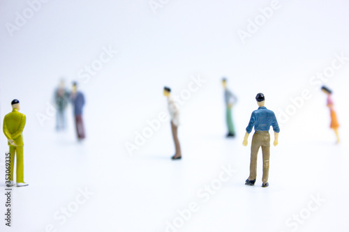 miniature businessmen keep distance away in the public. Social distancing concept avoid COVID-19 coronavirus spreading.