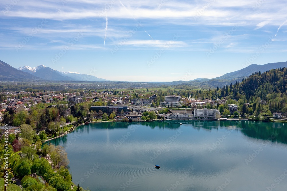 Fototapeta premium The hotels and commercial buildings without logos in Bled, Slovenia with a Blejsko jezero (Bled lake) in the foreground in a summer day